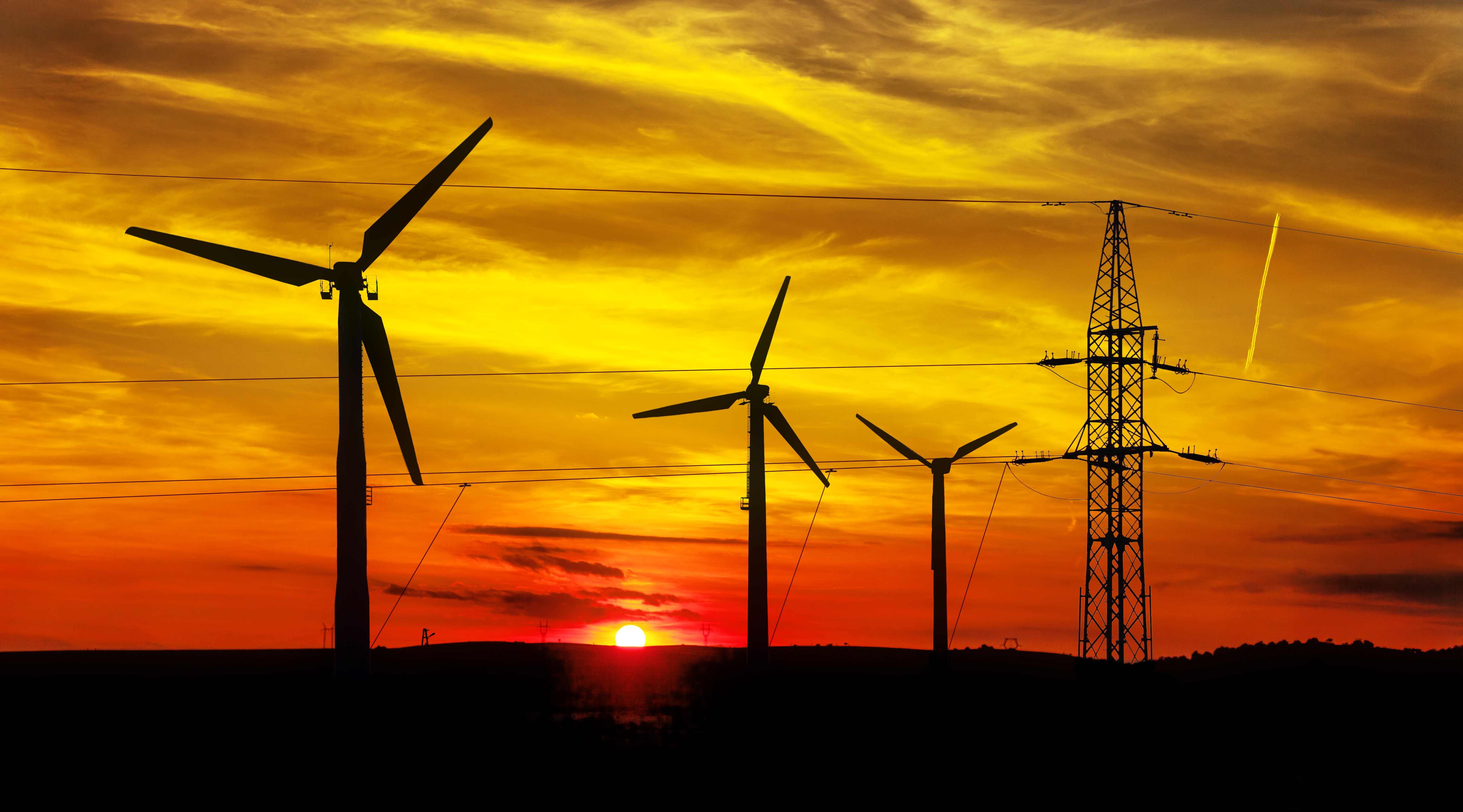 High Voltage Power Line and Wind Turbines at sunset